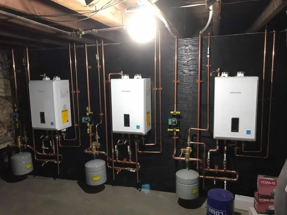 Three tankless water heaters installed on a wall by RPM